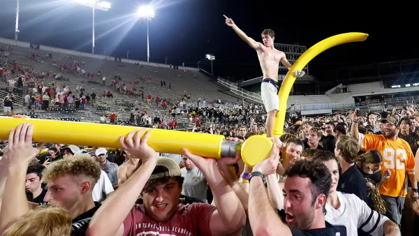 Vanderbilt fans carry a goal post off the field in celebration of the win